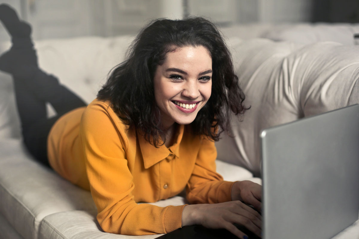 Een vrouw liggend op haar bank genietend van de reparaties uitgevoerd door Computerhulp Haarlem